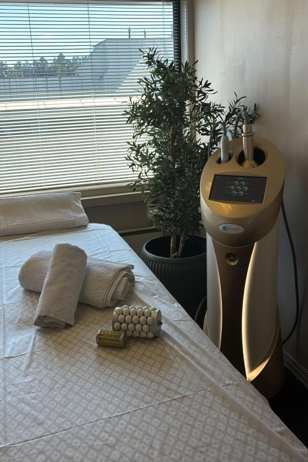 Et behandlingsrom med benk og behandlingsmaskin ved vinduet