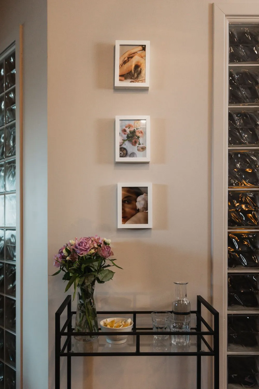 Et hjørne av klinikken med innrammede bilder og blomster